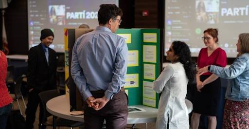 2 people talking in front of a presentation