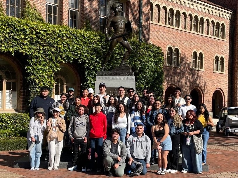 Students standing in front of USC statue